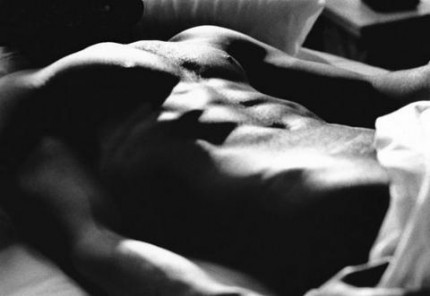 UN homme nu allongé sur un lit avec un très beau torse!