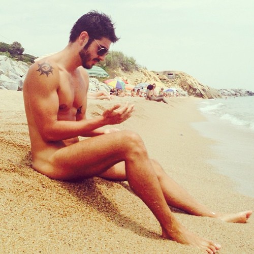 Jolie photo d’un homme nu brun sur une plage naturiste