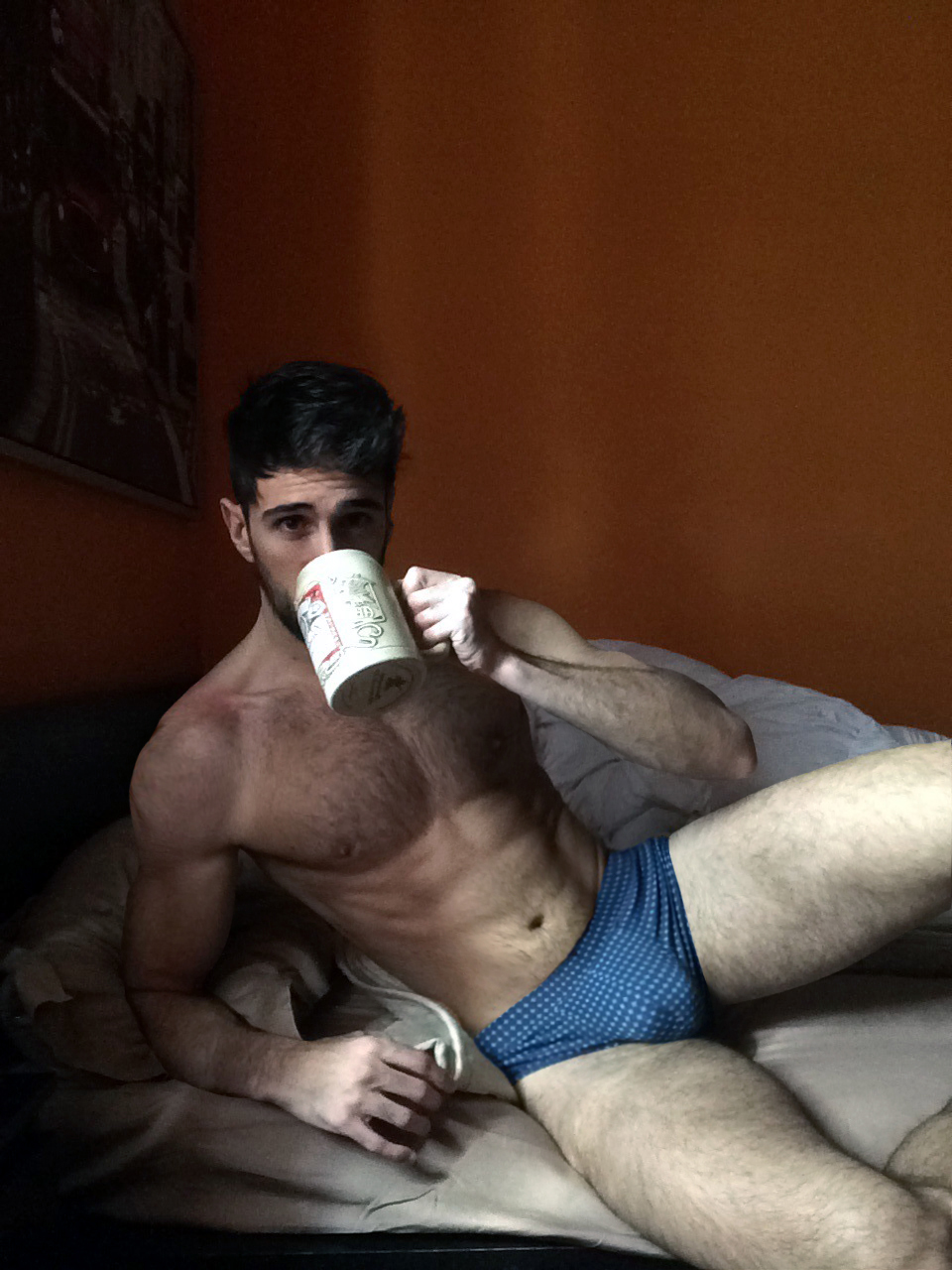 Photo d’un homme presque nu avec un gros bulge dans son lit