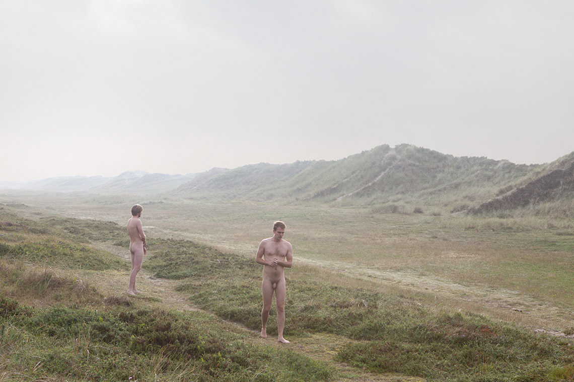 Un homme nu vous montre deux hommes nus face à la nature