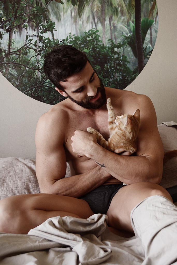 Photo d’un homme nu sur un lit avec un chat