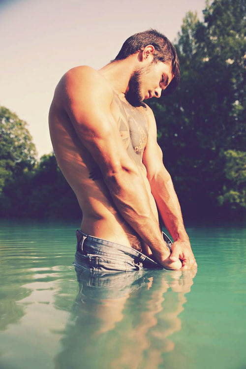 Très beau mec mignon tatoué torse nu dans l’eau