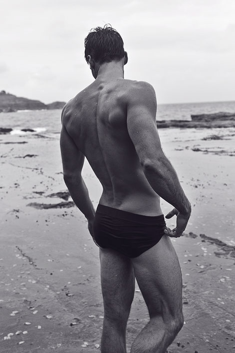 Photo d’un bel homme presque nu de dos sur la plage